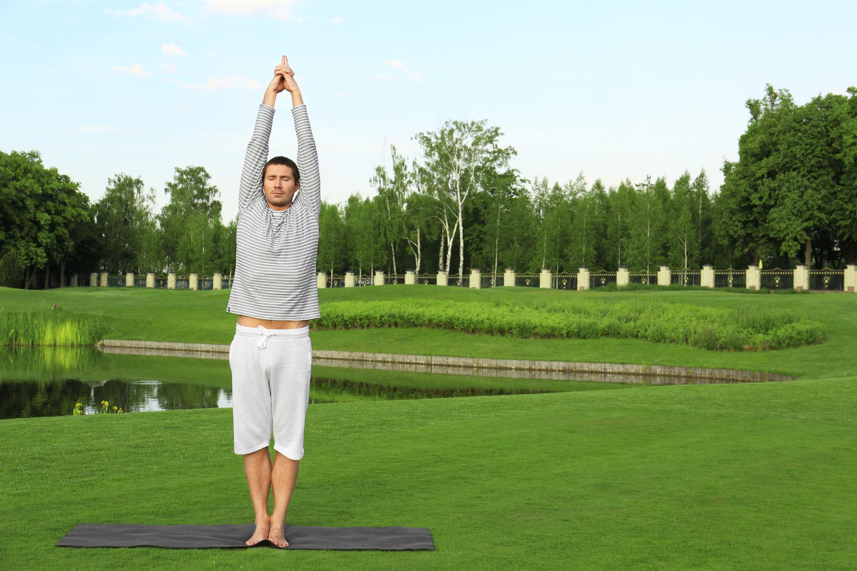 Young Man Practicing Yoga in Golf Course